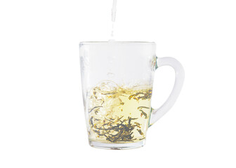 Adding hot water to a cup with green tea leaves. Shooted in motion.
