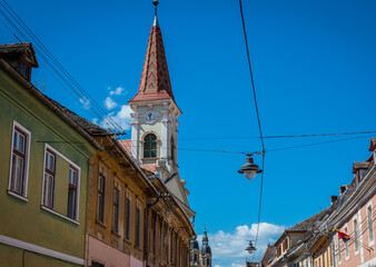 Fototapeta na wymiar Reformed Church bell tower seen from Mitropoliei Street in Old Town of Sibiu, Romania