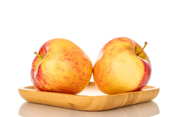 Two  ripe red apples on a bamboo tray, macro, isolated on white background.
