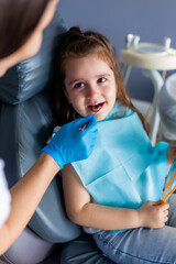 little brunette girl at a dentist appointment. Pediatric dentistry