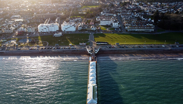 Paignton, Torbay, South Devon, England: DRONE VIEW: The drone shows an aerial view of Paignton Pier head, the sea, Paignton Green, the town of Paignton featuring two new build hotels on the seafront.