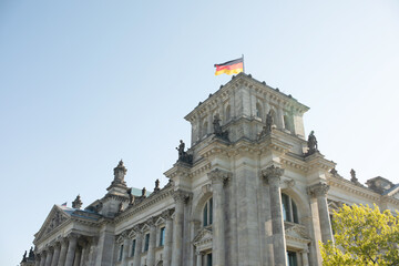 The Bundestag building, Parliament of the Federal Republic of Germany, with German flag flying outside.