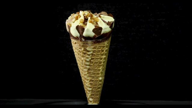 Helado de cucurucho derriti&eacute;ndose a c&aacute;mara r&aacute;pida en fondo negro