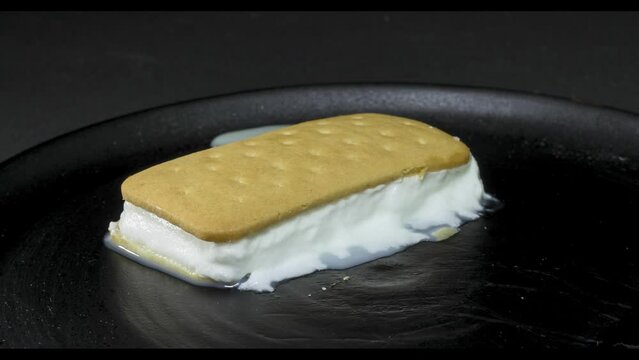 Helado sandwich de nata derriti&eacute;ndose a c&aacute;mara r&aacute;pida con fondo negro
