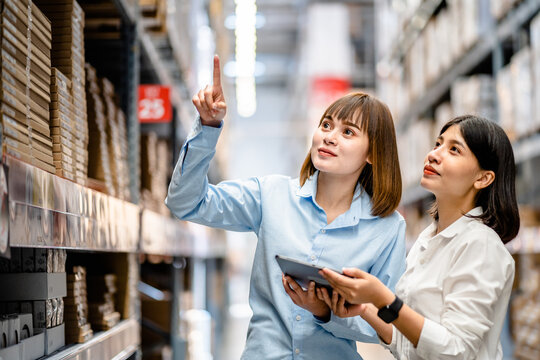 Warehouse staff working together using digital tablets to check the stock inventory on shelves in large warehouses, smart warehouse management system, supply chain, logistic network technology concept