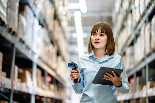 Women worker use scanner to check and scan barcodes of stock inventory on shelves to keep storage in a system, Smart warehouse management system, Supply chain and logistic network technology concept.