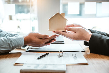 Sale Agent handshake with woman customer and sign agreement documents for realty purchase after successful loan contract