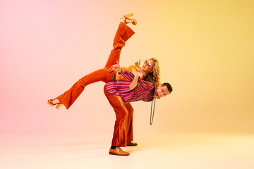 Boogie woogie. Emotional, expressive young couple, man and woman in stylish clothes dancing against...