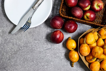 Fresh sweet ripe peaches and Medlar Fruits on gray grunge background 