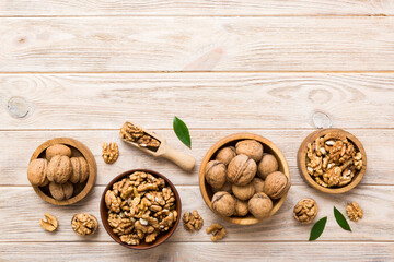 Walnut kernel halves, in a wooden bowl. Close-up, from above on colored background. Healthy eating Walnut concept. Super foods with copy space