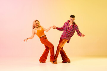 Beautiful, active, emotional couple, man and woman in vintage clothes dancing retro dance against...