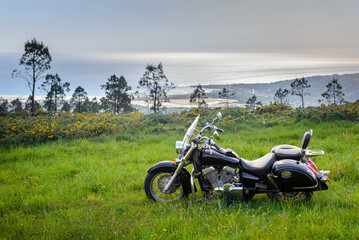 classic custom black motorcycle on the background of a beautiful landscape with the ocean, view from the mountain