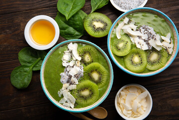 Green Smoothie Bowl with Spinach, Banana, Chia Seeds on Brown Background