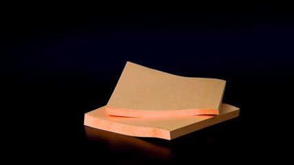 Sticky orange paper notes isolated on black background