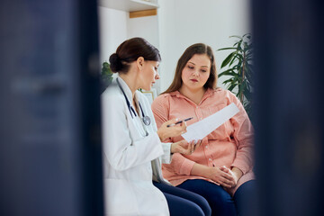 Fototapeta premium A female nutritionist explains a diet plan to a worried pretty curvy woman.