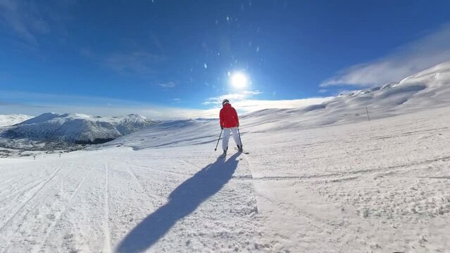 Female 35 year old skier skiing fast downhill Iin Myrkdalen Norway - Camera close to ground with snow hitting lens