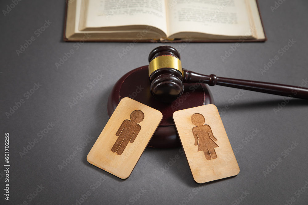 Wall mural Judge gavel with a male and female wooden symbols on the black background.