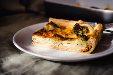 Sliced traditional french open quiche pie with cheese and broccoli