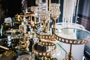 Table with plates stands for candy bar, catering. Decorating an event in restaurant. Wedding hall...