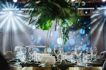 Banquet decoration composition flower greenery in hall. Luxury wedding reception. Table setting,...