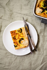 Sliced traditional french open quiche pie with cheese and broccoli