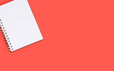 Opend blank notebook with white cover with spiral bound on red background. Business or education concept