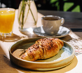 Cup of fresh hot coffee, orange juice and traditional french croissant on table of parisian outdoor cafe in paris