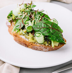 Sandwich with baked eggplant, sliced cucumbers and seeds