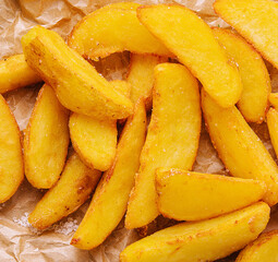 Baked fried potatoes close up background