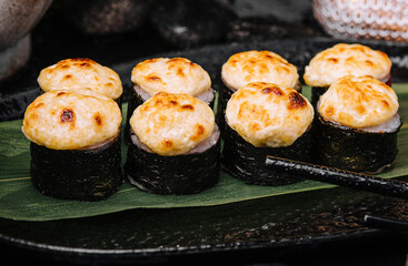 Served warm sushi rolled in nori sheets with ginger and wasabi