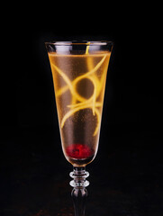 Elegant glass of yellow champagne with raspberry