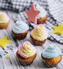 Delicious cupcakes with colorful cream on wood table