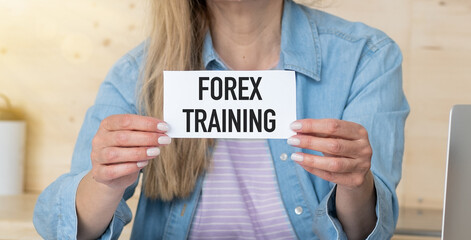 Against the background of the quote chart, a woman holds a sign with the inscription - Forex training