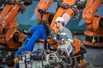 male automation engineer in uniform helmet safety inspection check control heavy machine robot arm system in industrial factory. technician worker check for repair factory machine