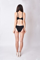 Young woman, brunette. Female model with black underwear, profile photo shoot.