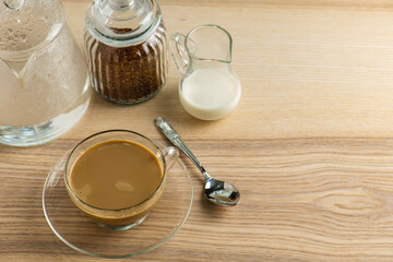 cup of hot Intense coffee dark shot in glass on wooden table with beans with crema. coffee beans and cup full of Intense dark shot coffee in glass cup