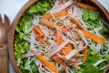 Hand chef mix fresh baby cos salad millet Crab Stick and pour salad dressing in wood blow. Organic Vegetables mix lunch with green salad In bowl. Breakfast fresh salad and clean vegetable