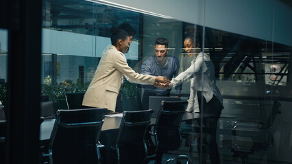 Multi-ethnic diverse business team coworkers colleagues corporate partners workers win with laptop celebrating good online result success stack hands put palms together united teamwork partnership