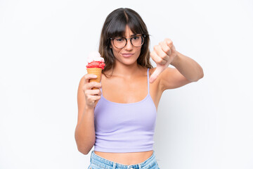 Young caucasian woman with a cornet ice cream over isolated white background showing thumb down with negative expression