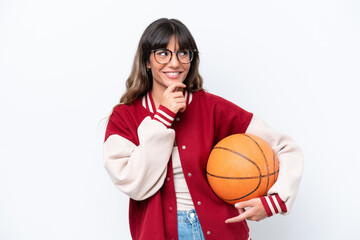 Young caucasian woman playing basketball isolated on white background looking to the side and...