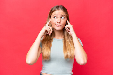 Fototapeta premium Young beautiful woman isolated on red background having doubts and thinking