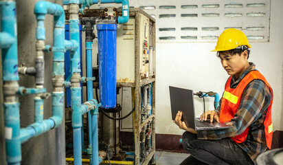 Engineer working in drinking water factory using a tablet computer to check water management system...