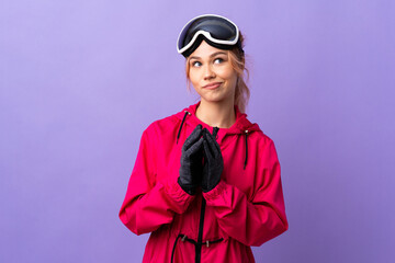 Skier teenager girl with snowboarding glasses over isolated purple background scheming something