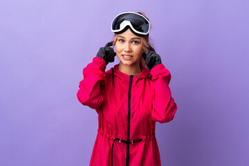 Skier teenager girl with snowboarding glasses over isolated purple background frustrated and covering ears
