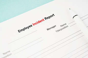 The Template of an Employee incident report form document and and pen on blue background.