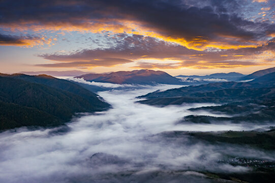Amazing flowing morning fog in summer mountains. Beautiful sunrise on background. Landscape photography © Ivan Kmit