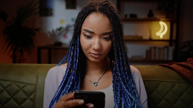 Close-up portrait of ethnic pretty woman expressing excitement and joy white checking her smartphone