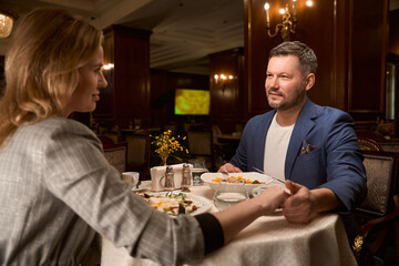 Man holding female hand after dinner at restaurant