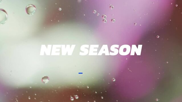 Animation of new season text over close up of liquid and baubles