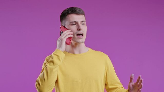 Annoyed young man quarreling while talking on mobile phone. Angry man, stress